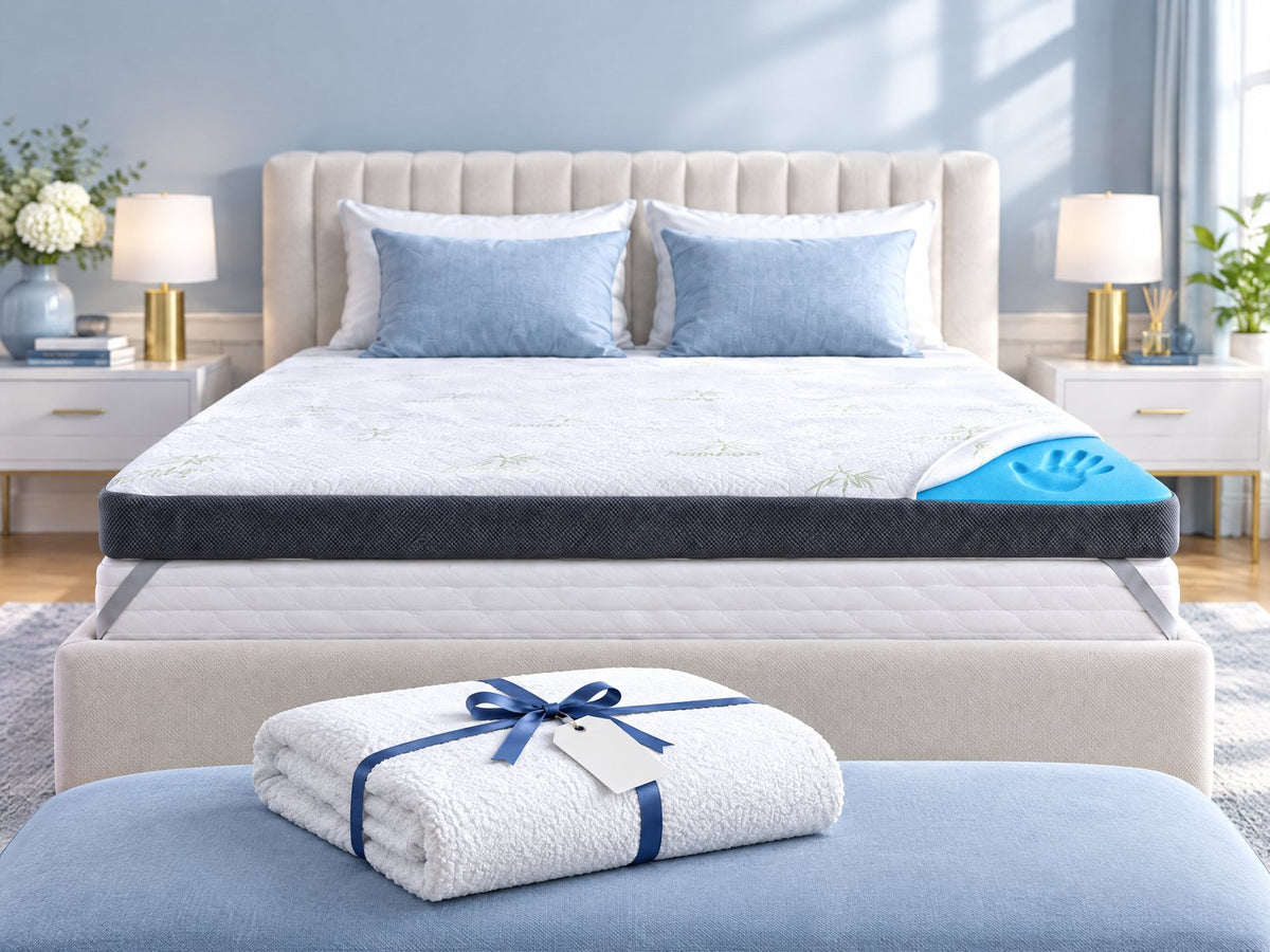 Premium Komfort Topper sur le lit, devant un protège-matelas plié avec un ruban cadeau